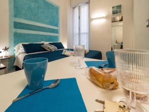 a living room with a table with glasses and a couch at Picagetta Tiny Room with AC in Vernazza
