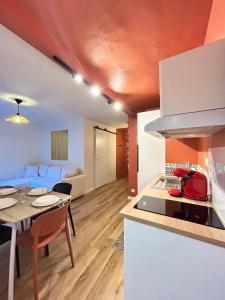 une cuisine et un salon avec une table et une chambre avec un lit dans l'établissement Le Terracotta, central et intimiste, à La Celle-sous-Gouzon