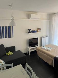 un soggiorno con un divano e una TV di Sciacchetrà Apartment with AC & Patio a Monterosso al Mare