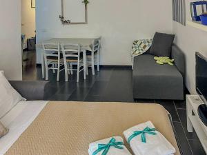 un soggiorno con un divano, un tavolo e delle sedie di Sciacchetrà Apartment with AC & Patio a Monterosso al Mare Altre 26 foto