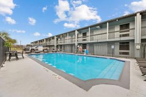 einem Pool vor einem Apartmentgebäude in der Unterkunft Days Inn & Suites by Wyndham Texas City in Texas City