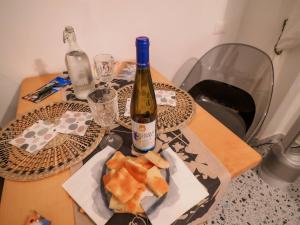 un tavolo con una bottiglia di vino e un piatto di cibo di Rissu Comfortable Village Life Studio a Vernazza