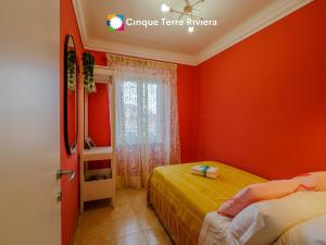 a red room with two beds and a window at Ca' Bea Apartment with AC and Terrace in Vernazza
