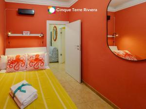 una camera da letto con pareti arancioni e specchio di Ca' Bea Apartment with AC and Terrace a Vernazza