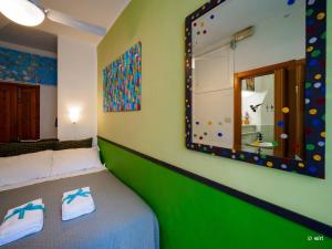 een slaapkamer met een bed met een spiegel aan de muur bij Carmelina Tiny Village Room in Vernazza