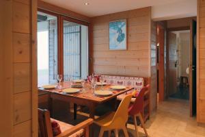 a dining room with a wooden table and chairs at Gîte Les Neufs Lieux in Gérardmer