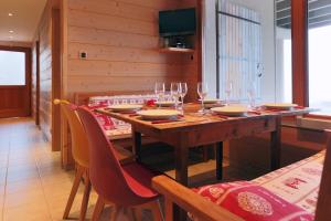 a dining room with a wooden table with wine glasses at Gîte Les Neufs Lieux in Gérardmer