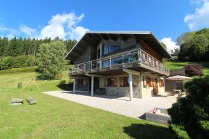 a house on a hill with a large yard at Gîte Les Neufs Lieux in Gérardmer
