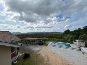 a car parked next to a house with a swimming pool at Cabang View - Hillstay Retreat in Kampung Padang Masirat