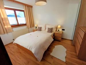 een slaapkamer met een groot wit bed en een raam bij Ferienwohnung Schösserhof in Reith bei Kitzbühel