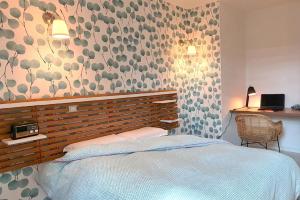 a bedroom with a bed and a floral wall at Pomme d'Happy in Autheux