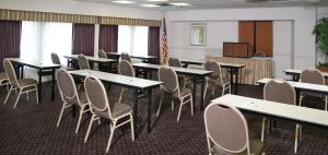 a room with tables and chairs and a television at Luxe Studios Nashville Opryland in Nashville