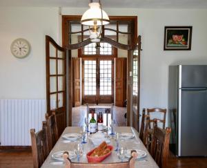 a dining room with a table and a refrigerator at Maison De Lafenestre in Saint-Maigrin