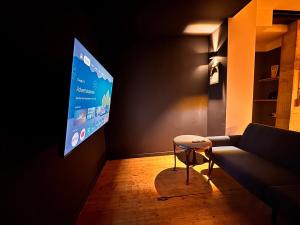 a living room with a couch and a tv on the wall at Hiddenhausen Premium Apartment mit Terrasse in Hiddenhausen