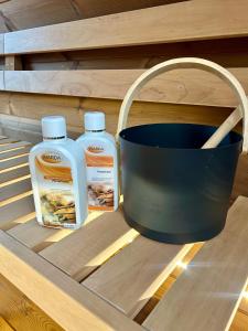 twee flessen zeep en een emmer op een plank bij Traumnest Eifel mit Sauna & Whirlpool in Monschau