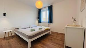 een kleine slaapkamer met een bed en een raam bij Jan Gustav Apartments in Liptovský Mikuláš