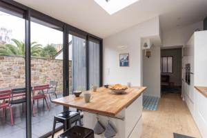 eine Küche und ein Esszimmer mit Glasschiebetüren in der Unterkunft Le Rock Fish - Quelques minutes de la plage in Dinard + 16 Fotos