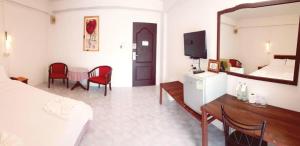 ein Hotelzimmer mit Bett, Tisch und Stühlen in der Unterkunft Hotel De Ratt Phuket in Ban Laem Hin + 78 Fotos