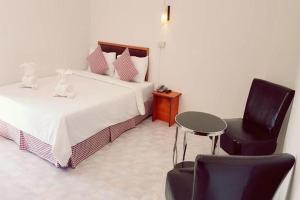 ein Schlafzimmer mit zwei Betten und einem Tisch und einem Stuhl in der Unterkunft Hotel De Ratt Phuket in Ban Laem Hin