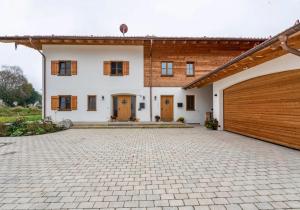 a large white house with a wooden garage at Eberlhof in Schechen