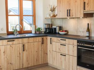 a kitchen with wooden cabinets and a sink at Eberlhof in Schechen