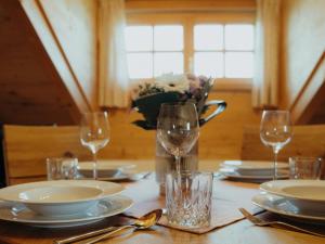 a table with plates and glasses and a vase of flowers at Eberlhof in Schechen
