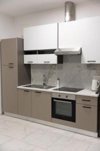 a kitchen with white cabinets and a sink at Luxury Apartment Brendi in Log pri Brezovici