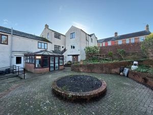 einen gemauerten Innenhof mit einem Gebäude und einem Gebäude in der Unterkunft The Chepstow Hive in Chepstow