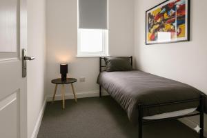 a small bedroom with a bed and a small table at Esk View House,Carlisle in Carlisle