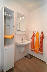 un bagno con lavandino, specchio e asciugamani di EulenNest a Rüde Altre 18 foto