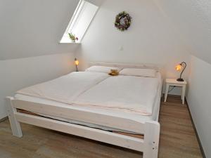 un letto bianco in una camera bianca con finestra di EulenNest a Rüde