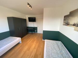 een kamer met een bed en een tafel met een tv bij Altona365 - ApartE in Rellingen