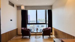 a room with a table and chairs and a window at Pheonix Luxury Inn in Akolia