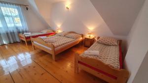 a attic bedroom with two beds and a window at Villa Poronianka in Poronin