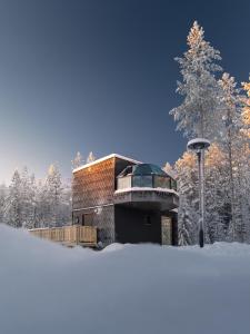 un edificio en medio de un bosque cubierto de nieve en SkyView Igloo Resort, en Rovaniemi
