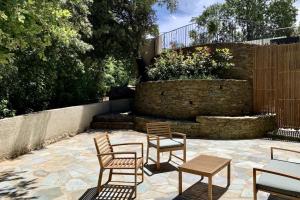 un patio con 4 sedie, un tavolo e una fontana di Domaine Ghjulia - Casa Nebbiu a Patrimonio