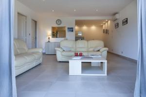 un soggiorno con mobili bianchi e tavolo di Domaine Ghjulia - Casa Nebbiu a Patrimonio