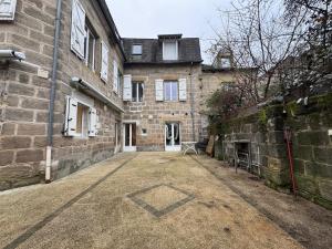 ein großes Steingebäude mit einem Innenhof davor in der Unterkunft Le Kandinsky, moderne et spacieux in La Celle-sous-Gouzon