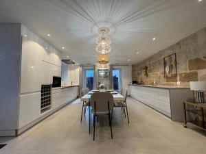 eine Küche mit Tisch und Stühlen und einem Kronleuchter in der Unterkunft Le Kandinsky, moderne et spacieux in La Celle-sous-Gouzon