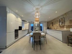 ein Esszimmer mit Tisch und Stühlen in einer Küche in der Unterkunft Le Kandinsky, moderne et spacieux in La Celle-sous-Gouzon