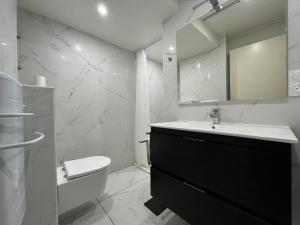 ein Badezimmer mit Waschbecken, Toilette und Spiegel in der Unterkunft Le Kandinsky, moderne et spacieux in La Celle-sous-Gouzon + 26 Fotos