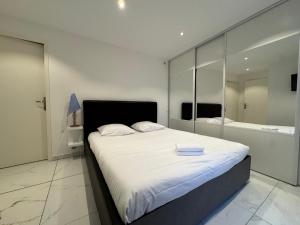 ein Schlafzimmer mit einem großen weißen Bett und einer Badewanne in der Unterkunft Le Kandinsky, moderne et spacieux in La Celle-sous-Gouzon