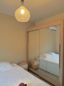 une chambre avec deux lits et un grand miroir dans l'établissement Le Borie climatisé, à Arles