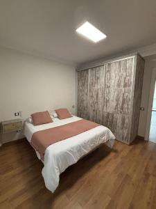 een slaapkamer met een groot bed en een houten vloer bij Casa Mares in Teror