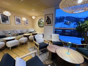 a restaurant with tables and chairs and a large window at Hôtel Club Le 1850 Risoul in Risoul