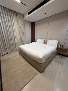a bedroom with a large bed with white sheets at Excellence Apartment شقه التميز في المونسيه in Riyadh