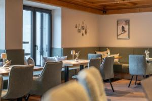 a dining room with tables and chairs and windows at Edelweiss echt-charmant in Sölden