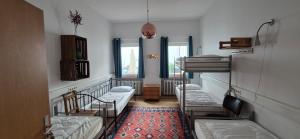 a room with three bunk beds and a rug at Hostel Très Schick in Bamberg +38 photos