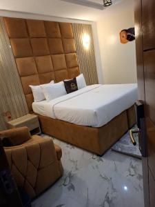 a bedroom with a large bed and a couch at Nice-mason Serene and Suites in Benin City