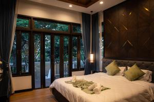 een slaapkamer met een groot bed met een groot raam bij Chevana Resort in Ban Doi Yao